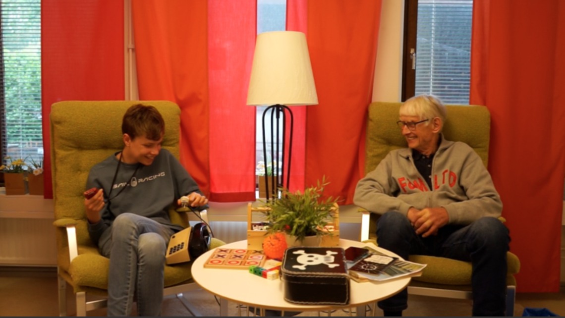 En ungdom från Fritidsträffen skrattar i ett samtal med fastighetsskötare Sven
