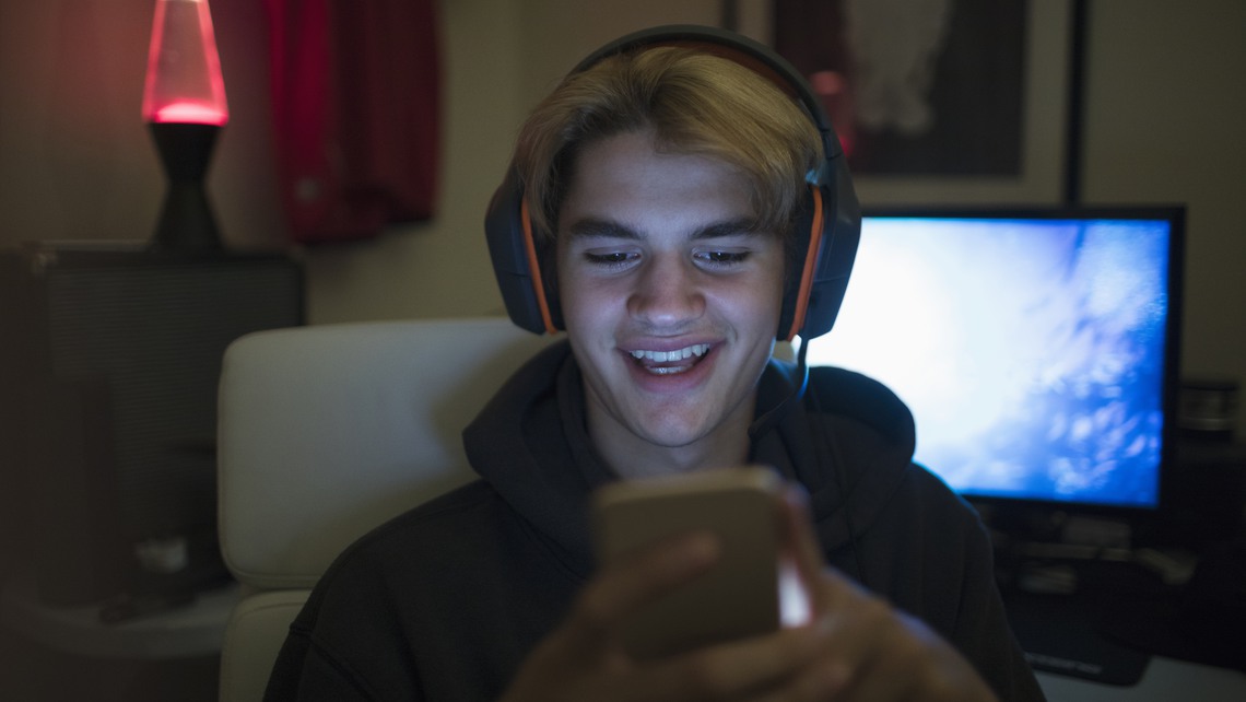 Ung kille spelar på mobilen
