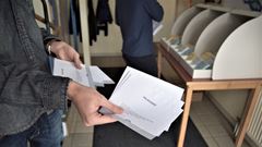 En person håller i några valkuvert.
