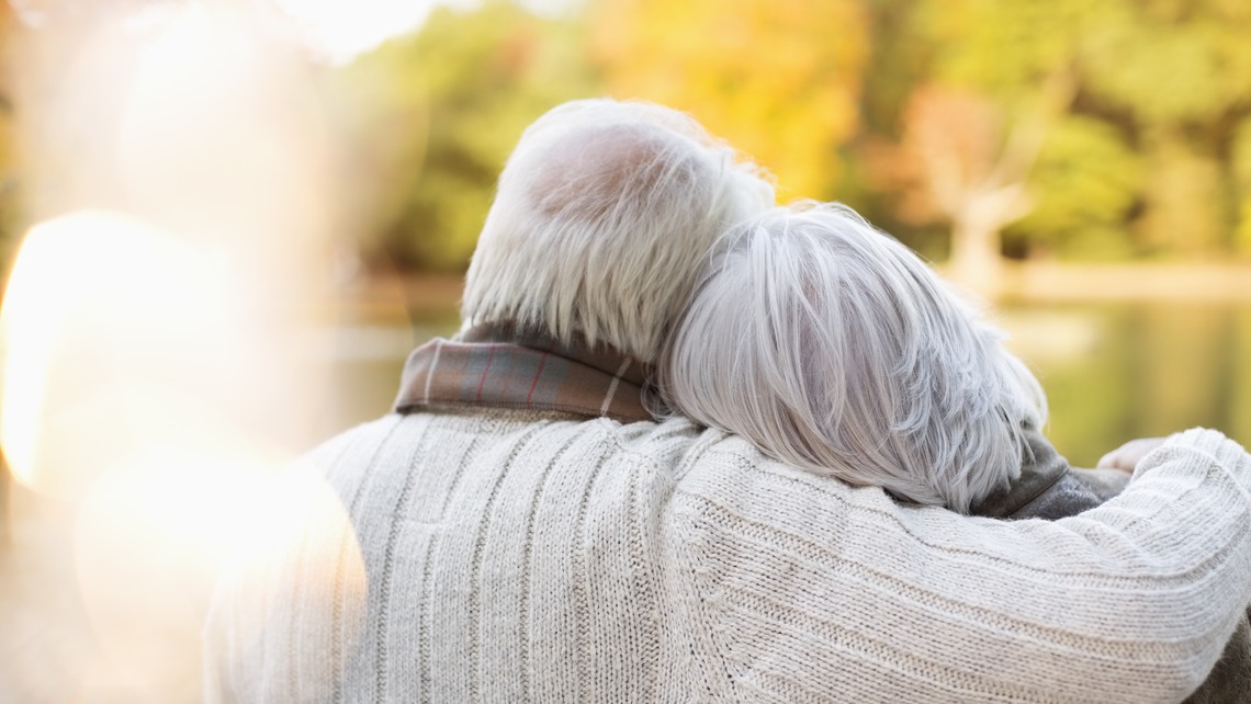 Older couple hugging in park