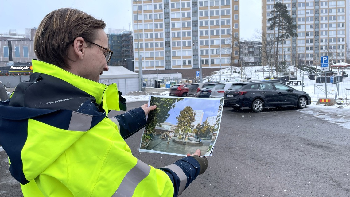 Kommunens projektledare Mats Falås håller upp en visionsbild av hur platsen kommer att se ut om ett par år.