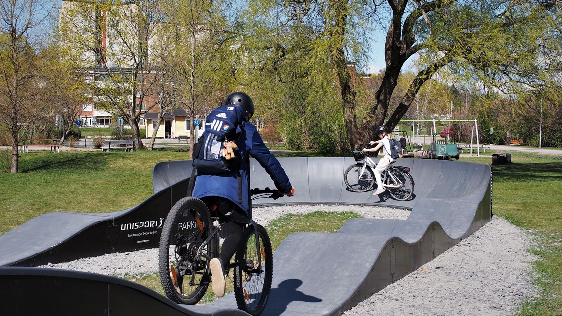Tjejer cyklar i cykelbanan vid Lärkängen