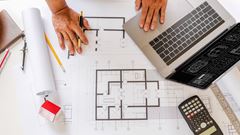 Blueprints of designer and engineers working at architects office desk.