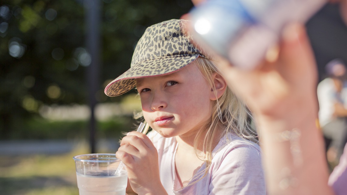 Flicka dricker vatten på ute servering