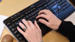 Närbild av händer som knappar på tangentbord.