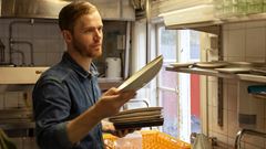 Man sorterar disk i restaurangkök.