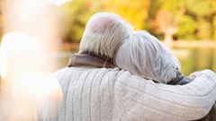 Older couple hugging in park