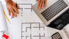 Blueprints of designer and engineers working at architects office desk.