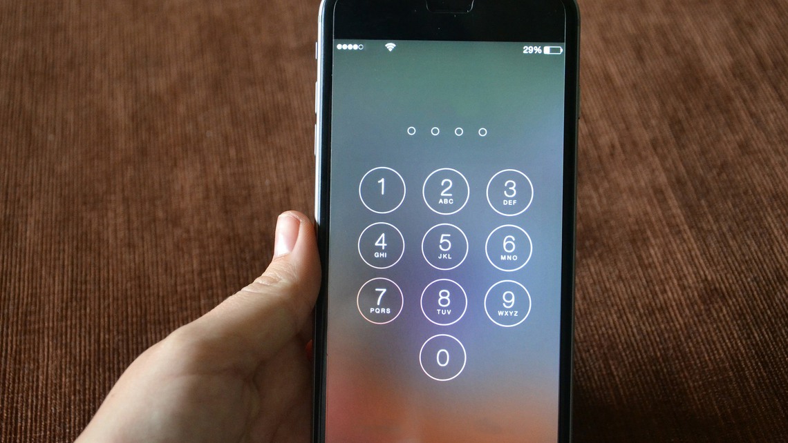 Hand som håller upp mobiltelefon med knappval.