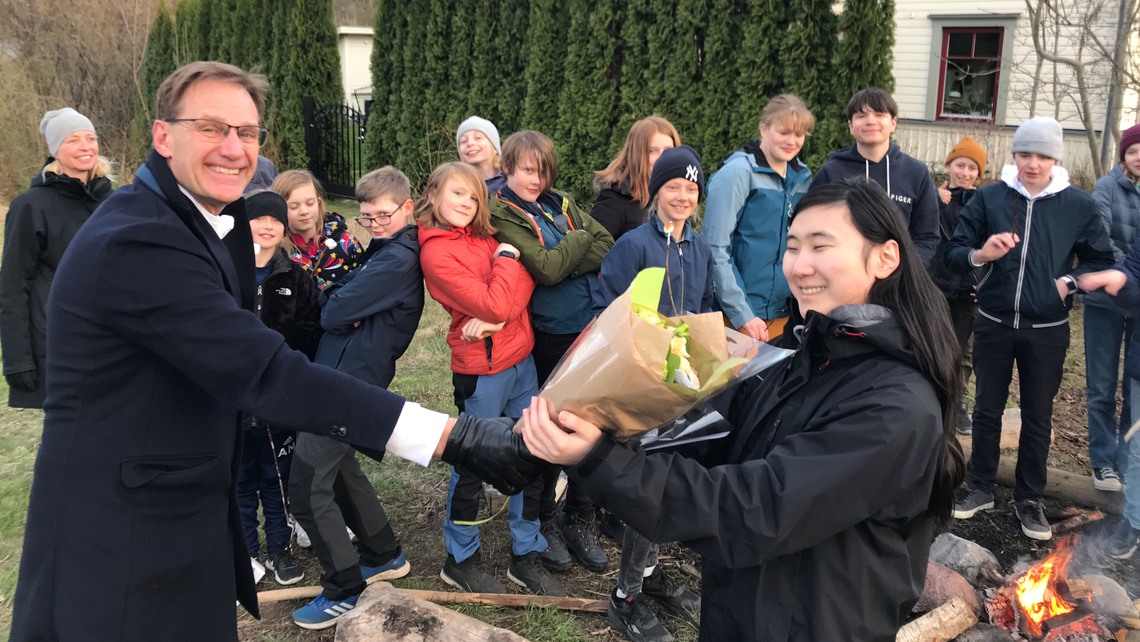 Kultur- och fritidschefen delar ut blommor till ungdomsledaren Amy från Stocksunds scoutkår.