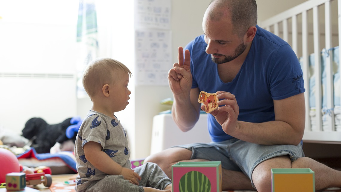 Pappa leker och talar teckenspr&aring;k med sin son