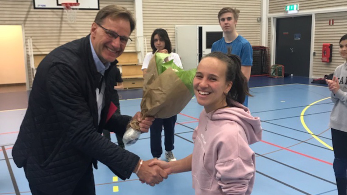 Kultur- och fritidschefen delar ut blommor till Angela Fjelde.