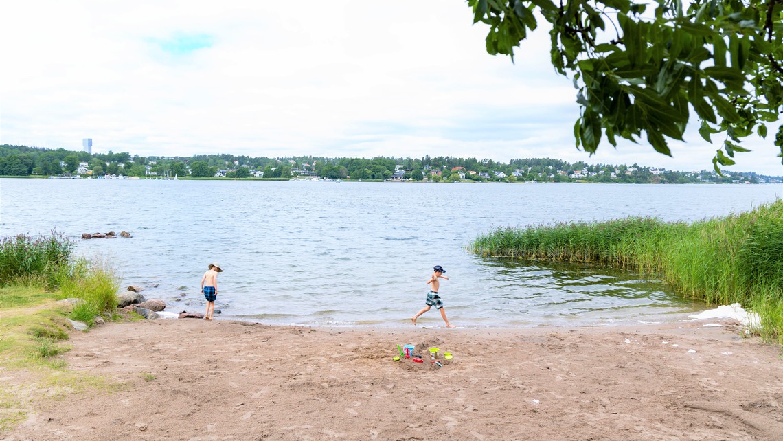 Två barn leker vid strandkanten.